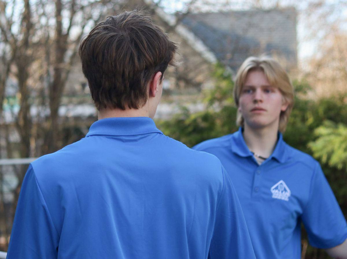 Two Value Window Washing student cleaners in blue uniforms talking between jobs